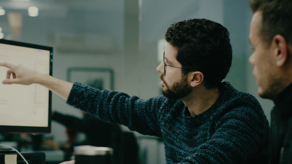 Arquitetos analisando plantas inteligentes no desktop